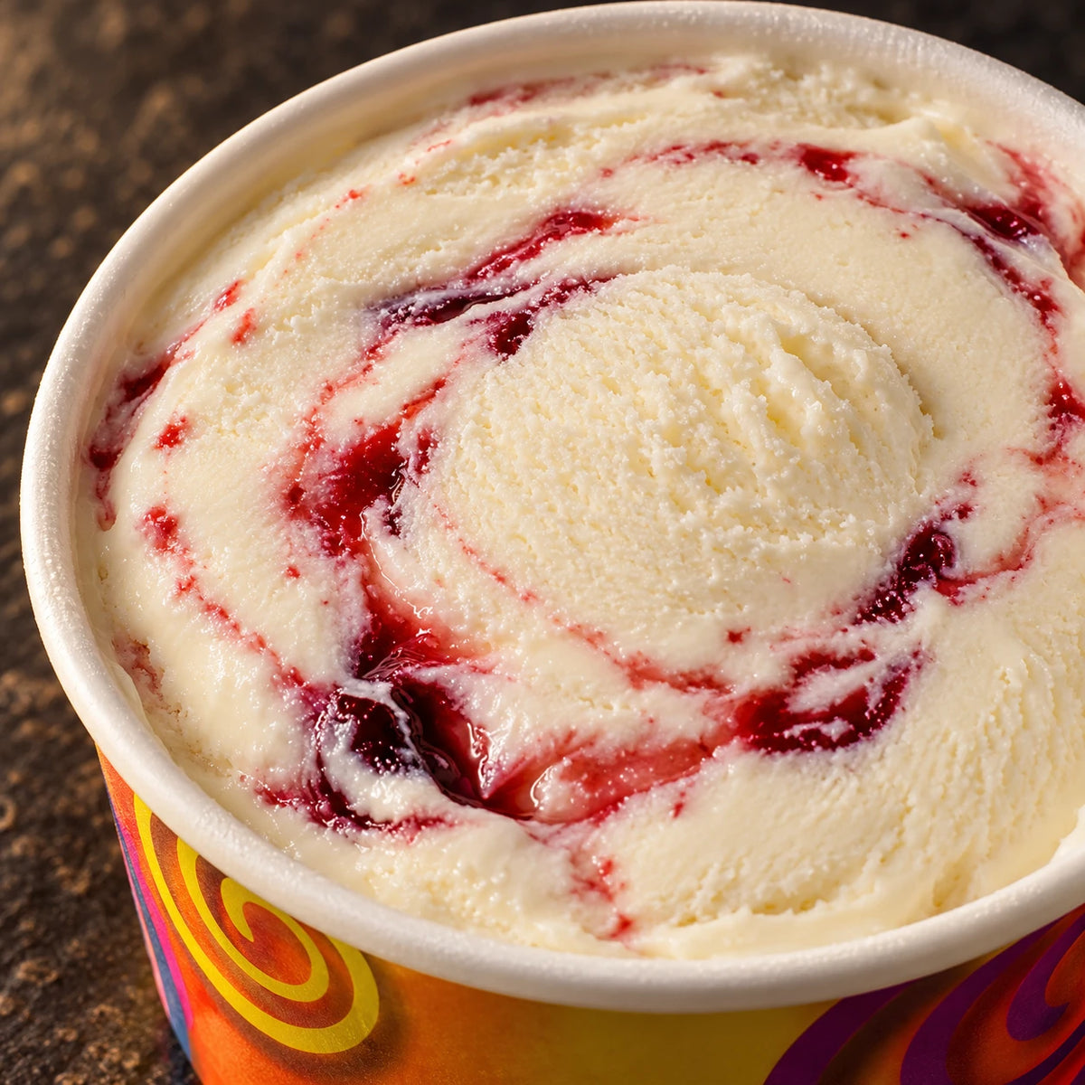 Primer plano de helado de leche con salsa roja de cereza en el vasito