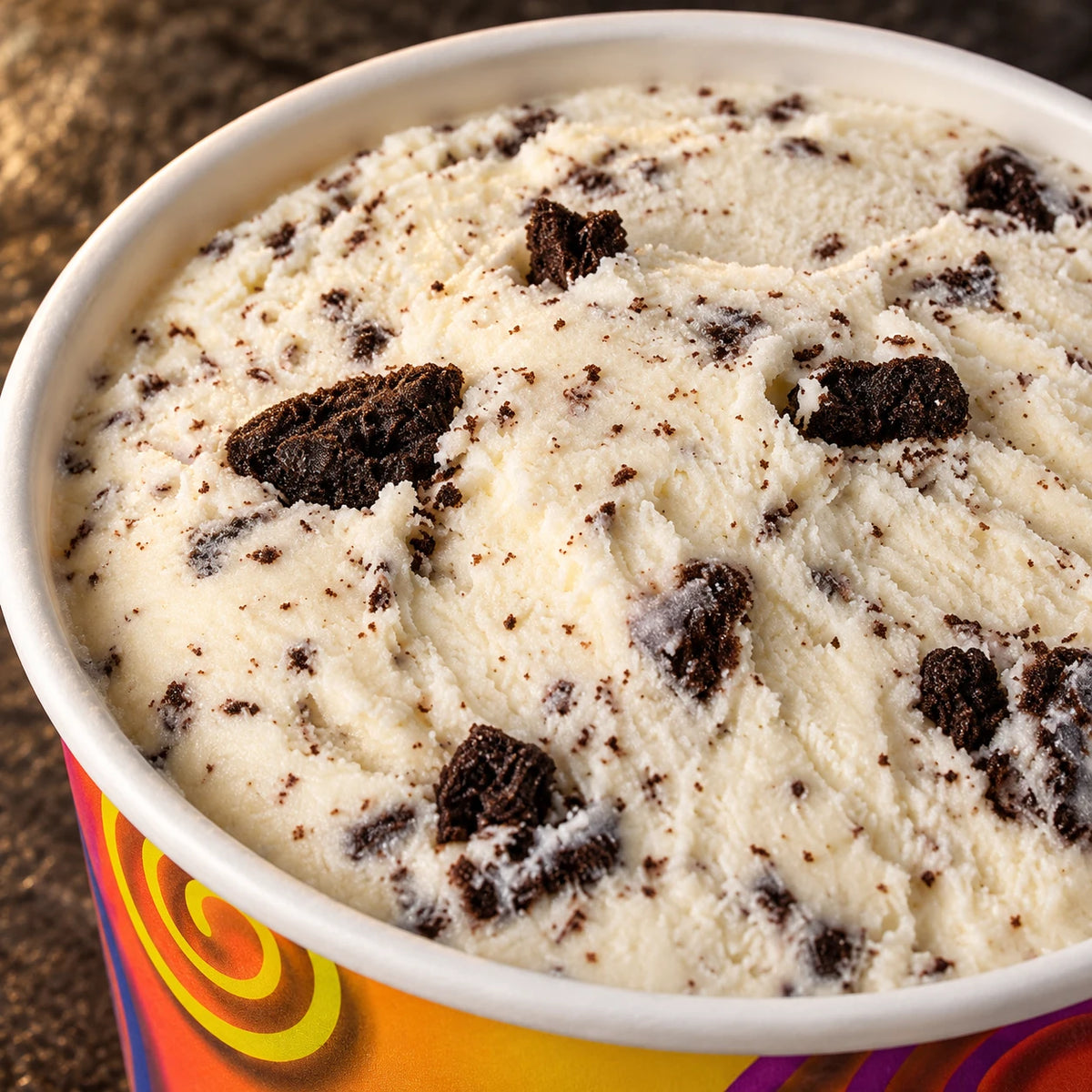 Primer plano de helado de leche claro con trocitos oscuros de galleta de cacao en el vasito