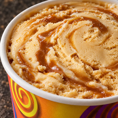 Primer plano de helado de caramelo con brillante salsa de caramelo en el vasito