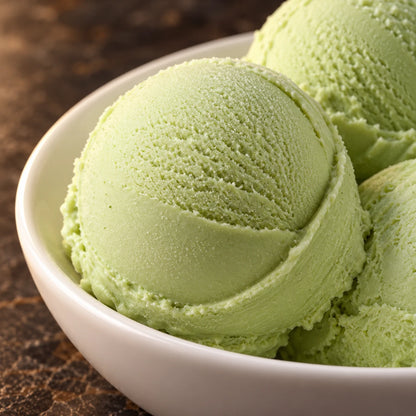 Primer plano de bolas de helado de pistacho en un cuenco blanco