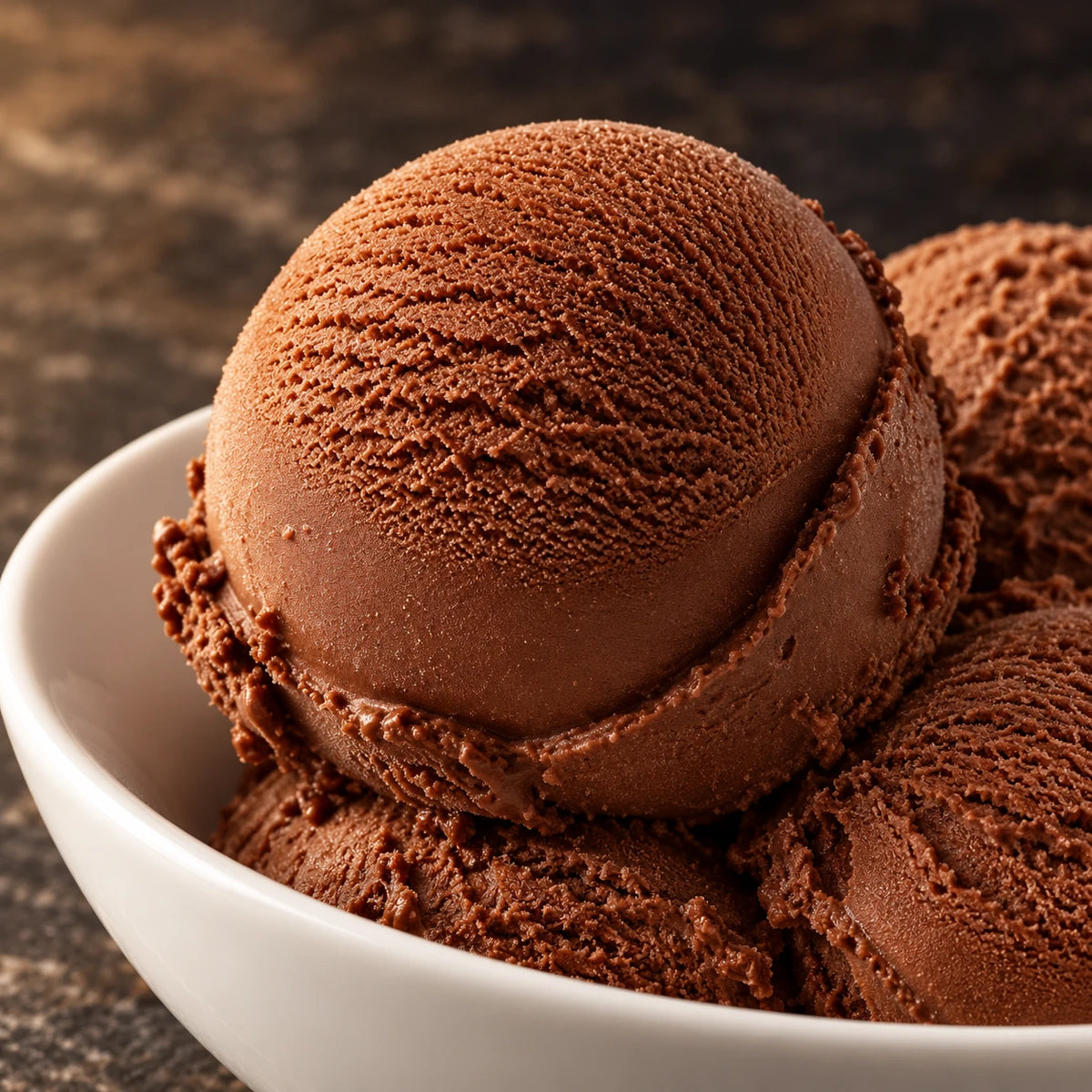 Primer plano de bolas de helado de chocolate en un cuenco blanco