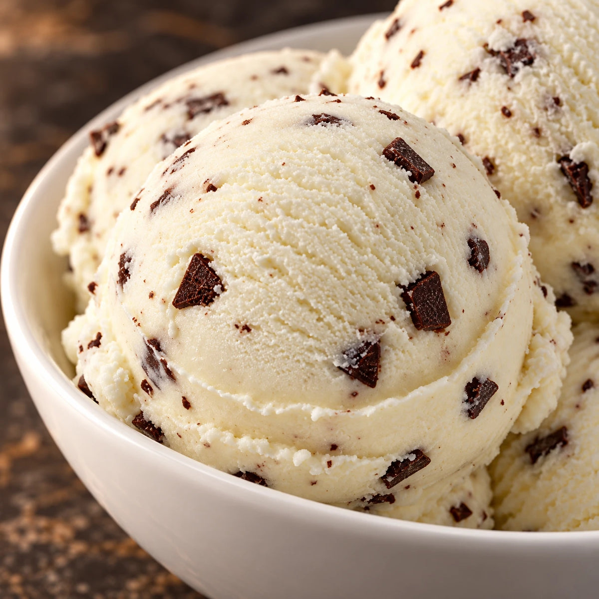 Primer plano de bolas de helado de stracciatella en un cuenco blanco