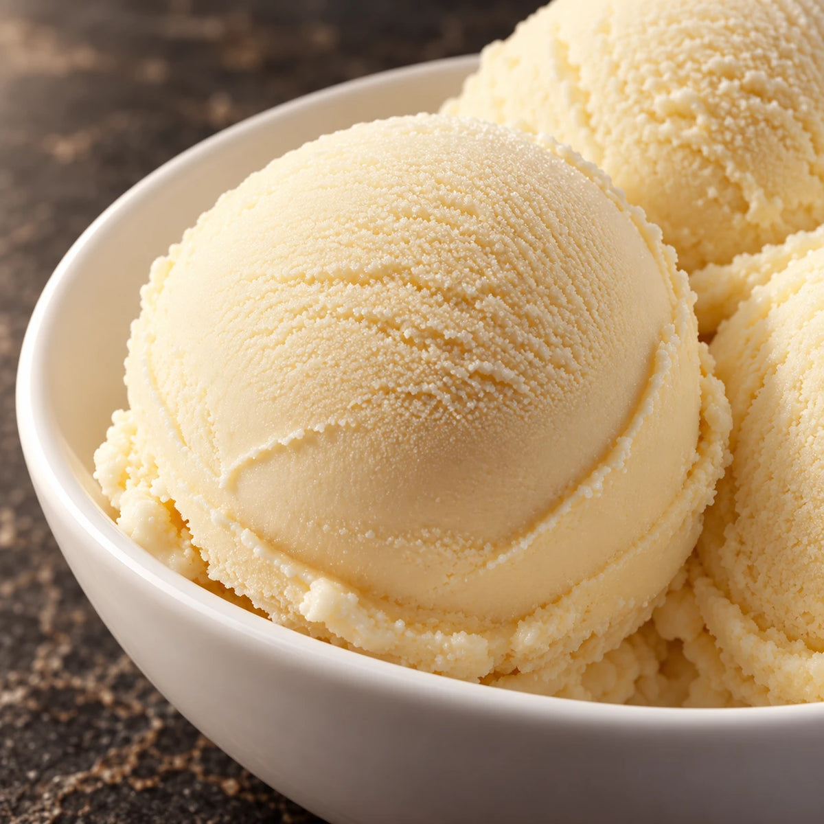 Primer plano de bolas de helado de vainilla en un cuenco blanco