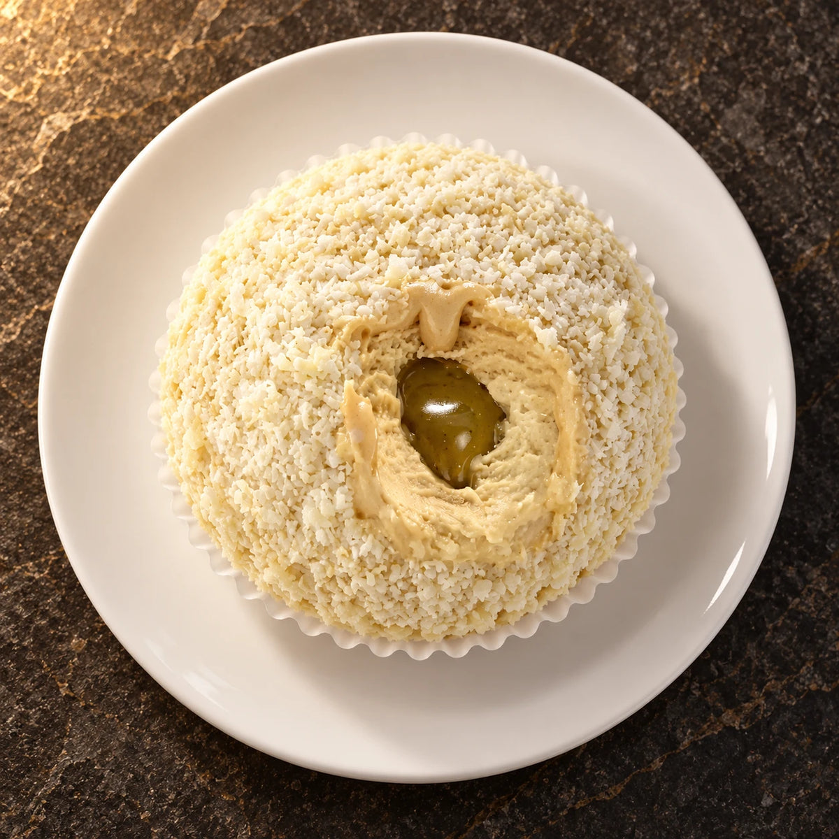 Tartufo de pistacho en cápsula visto desde arriba en un plato blanco
