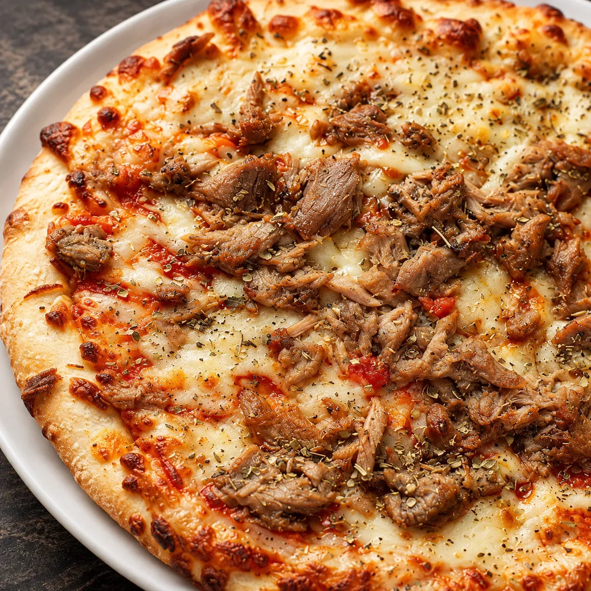 Primer plano: pizza de atún con atún desmenuzado, mozzarella fundida y orégano