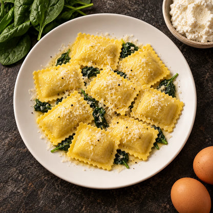 Regali Spinaci e Mascarpone su piatto bianco visto dall'alto su pietra scura, accanto gli ingredienti