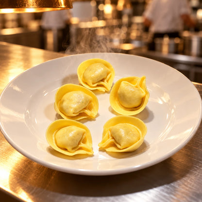 Tortellini al Brasato di Manzo na bijelom tanjuru na izdavanju profesionalne kuhinje