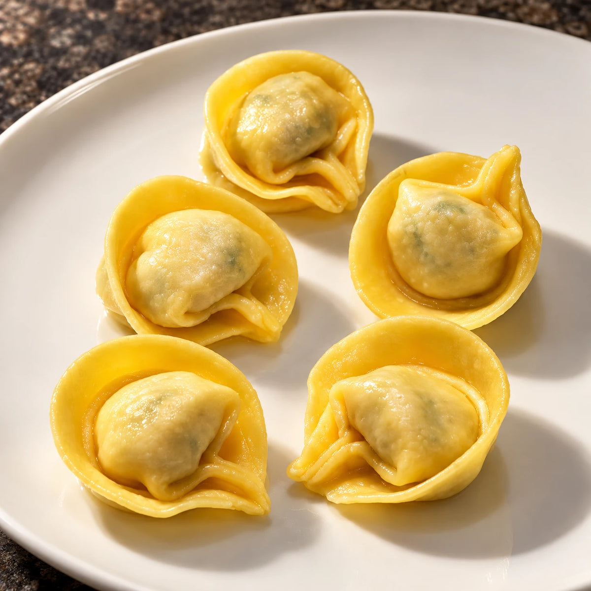 Primo piano di Tortellini Ricotta e Spinaci su piatto bianco